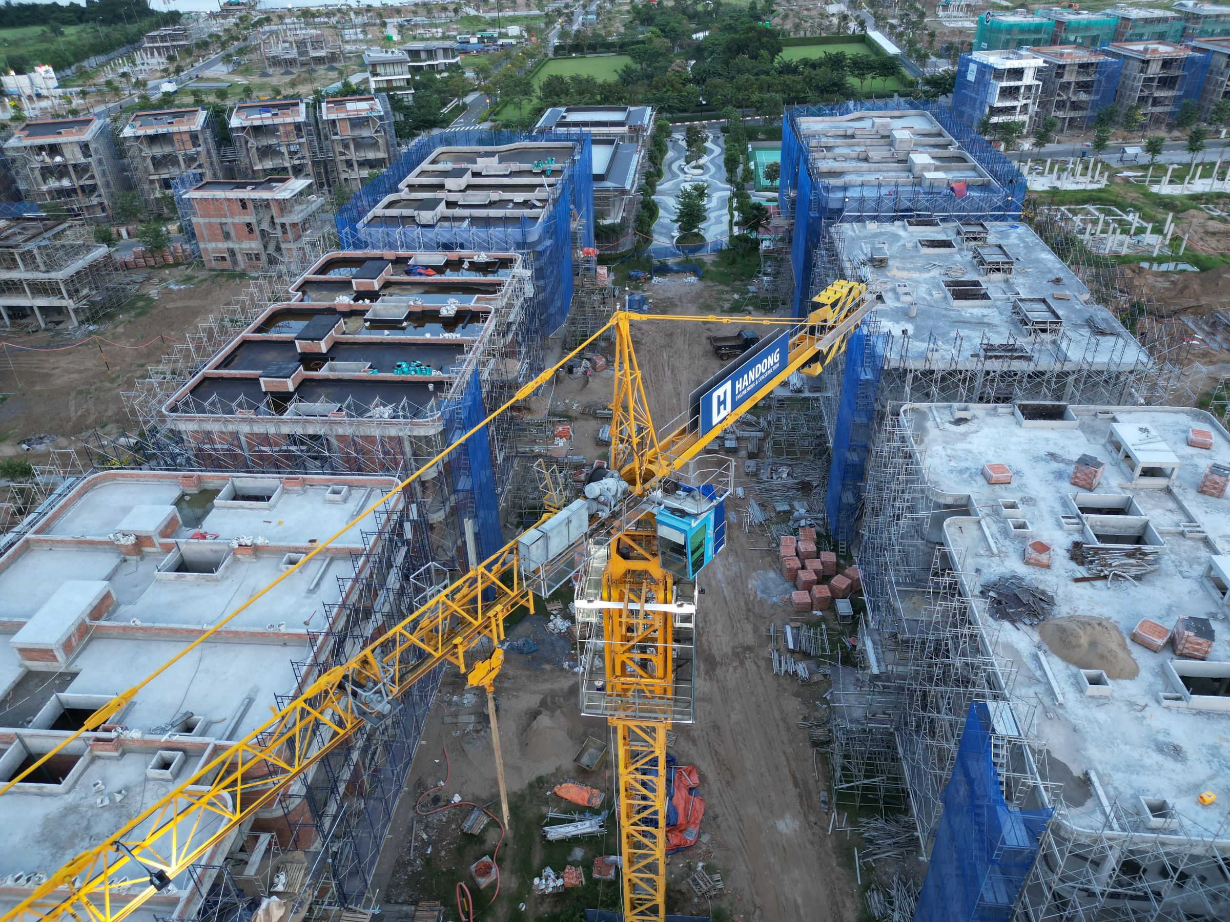 Stock drone view of a tower crane and buildings under construction